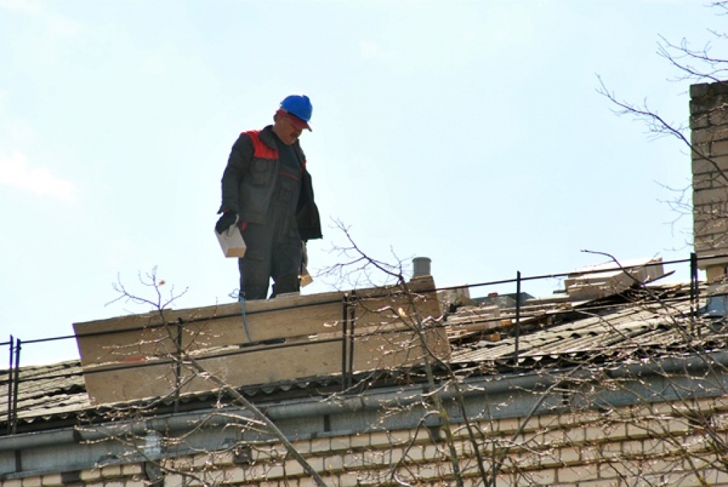 SIA «Bauskas namsaimnieks» strādnieks veic darbus uz Salātu ielas 14. mājas jumta. 
Autors: Uldis Varnevičs