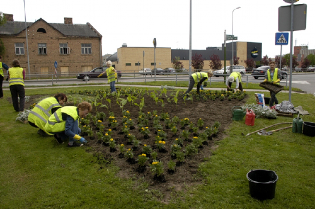 SIA «Vides serviss» strādnieces ziedus izstāda dobēs «deputātu stūrītī». Tā tautā dēvē laukumu Lāčplēša un Zaļās ielas krustojumā. 
Autors: Ivars Bogdanovs