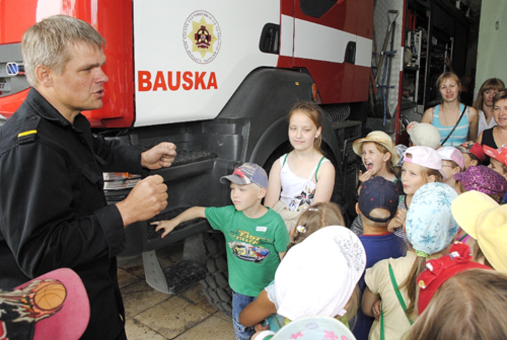 Uldis Bundzinskis stāsta nometnes «Vasaras mugursoma» dalībniekiem par mašīnām un ugunsdzēsēju darbu. 