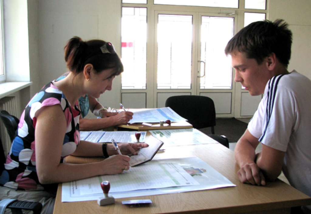 Parakstu vācēja Sanita Stikute Bauskā noformē dokumentus Andim Beķerim. Students atsteidzies parakstīties, jo viņu uzrunājušas pēdējo dienu informatīvās kampaņas, tostarp arī laikrakstā «Bauskas Dzīve». 
Autors: Vilnis Auzāns