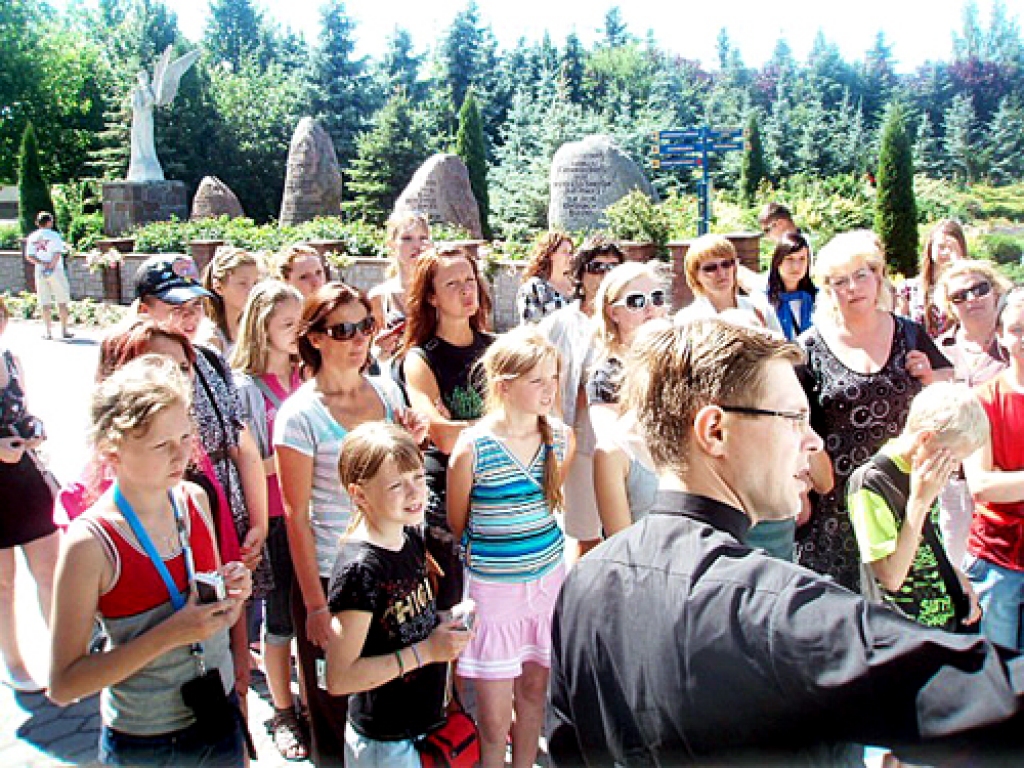 Arnis Vizbelis, Iecavas katoļu draudzes priesteris (priekšplānā), Misas vidusskolas koristiem vada ekskursiju Lihenē. 