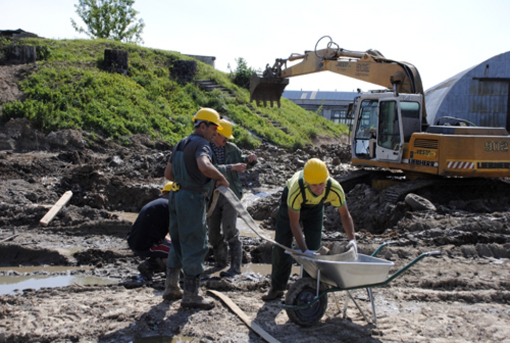 SIA «Vesta ABM» strādnieki gatavojas atsūknēt lietusūdeni, kas piepildījis topošās attīrīšanas stacijas būvlaukumu. 
Autors: Ivars Bogdanovs