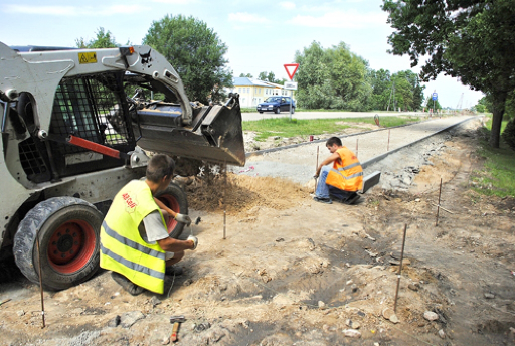 Pilnsabiedrības «AB Ceļi–Kvēle» strādnieki Jānis Melnis (no kreisās), Andris Melnis un Jevgeņijs Jonovs nospraustā celiņa robežās gatavo pamatni bruģa seguma klāšanai.  
Autors: Ivars Bogdanovs
