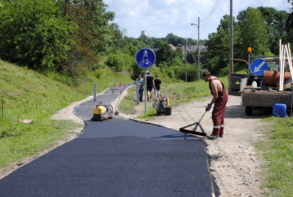 Uzņēmuma «Vides serviss» darbinieki ieklāj asfalta segumu gājēju celiņā, kas no Kundziņkroga Codē ved lejup uz Bausku. 
Autors: Ivars Bogdanovs