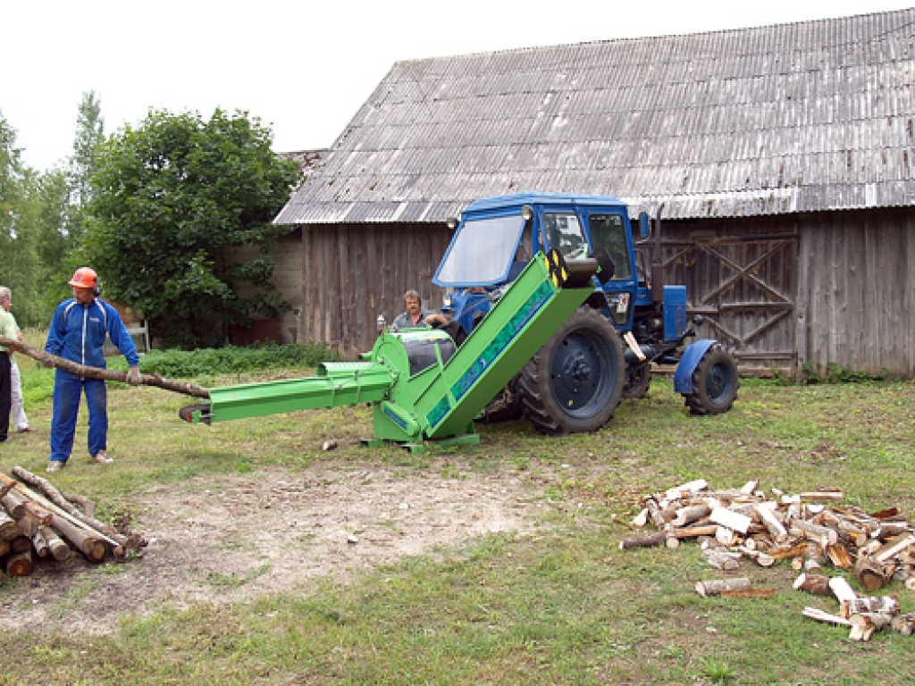 Ozolainietis Arvīds Dravnieks praksē demonstrē pārvietojamā malkas zāģa – skaldītāja darbību.