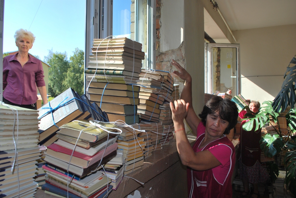 Bibliotekārei Lilitai Spurei (no kreisās) makulatūru palīdz iznest Jeļena Laika un Sarmīte Saktiņa, aiz kadra vēl viena palīdze – Dzidra Muižzemniece. 
Autors: Uldis Varnevičs