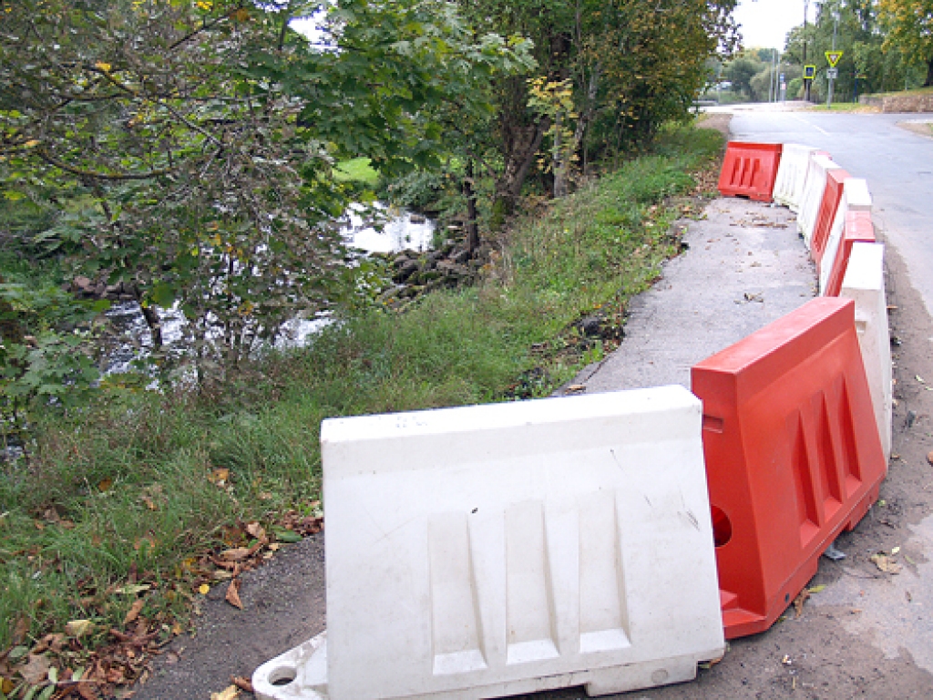 Iecavas upes krasts, kas nobrucis pirms gada, joprojām par pusi sašaurina brauktuvi Upes ielā.