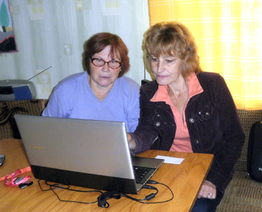 Bibliotēkas speciāliste Aina Mūrniece (no labās) māca Janīnu Albranti. 