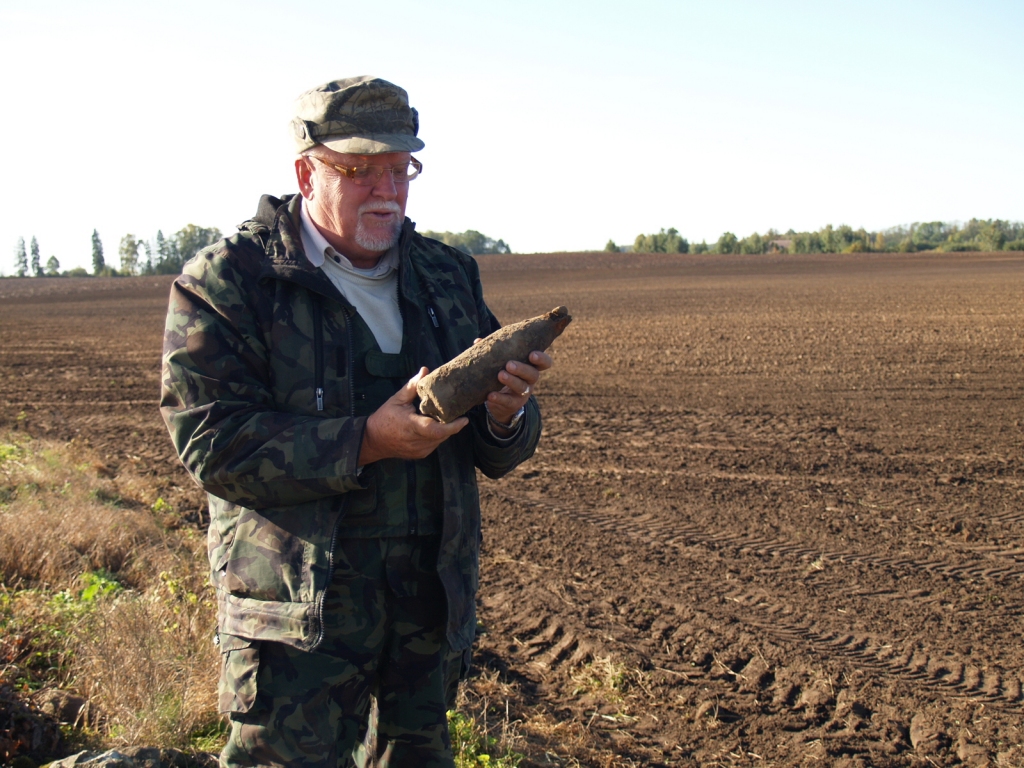 Jānis Bite nopēta no zemes izcelto, joprojām bīstamo mīnu – tās apvalks bojāts nedaudz, detonators ir vietā.
Autors: Antra Ērgle