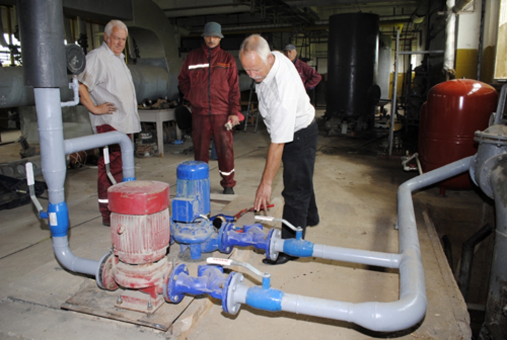 Oļģerts Līkais (no labās), Mežotnes pagasta pārvaldes vadītājs, slavē SIA «Bauskas siltums» remontbrigādi – Uldi Pīli (no kreisās), Aivaru Brišku un Juriju Bračkus (aizkadrā) – par profesionālu darbu. Pārvaldnieks skata modernos apkures sistēmas pretatplūdes vārstus. 
Autors: Juris Iļņickis