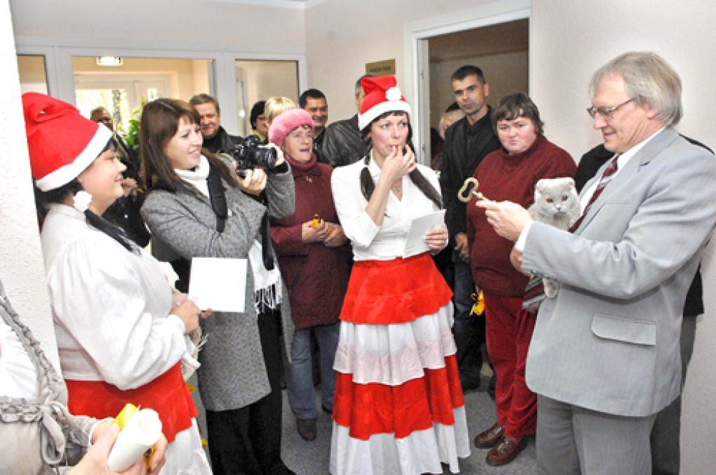 Rundāles novada sociālā centra atklāšanā kā īstos svētkos. Novada domes priekšsēdētājs Aivars Okmanis (no labās) ar simbolisko rekonstruētā centra atslēgu, kā arī mājas svētības sargātāju kaķi. 