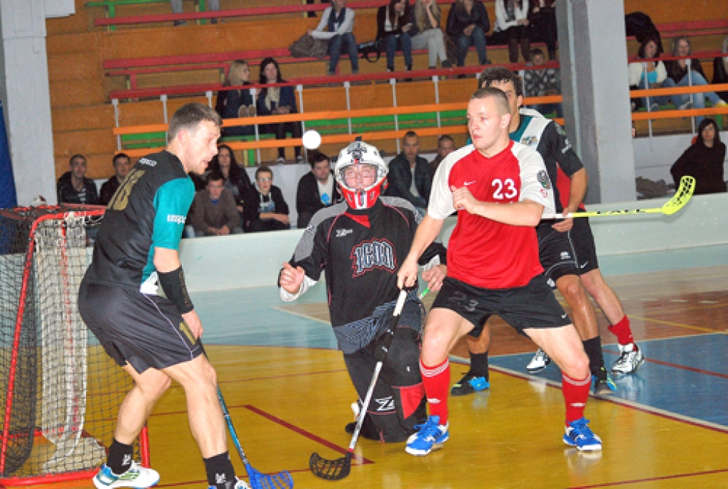 Elvis Holsts (vārtos) un Toms Rozentāls (23. numurs) cenšas nepazaudēt ātro un neparedzamo bumbiņu.  