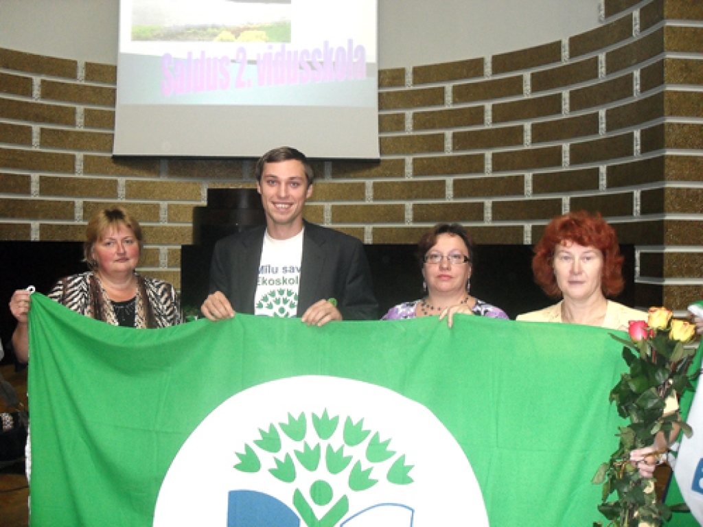 Dzimtmisas skolotājas Velga Ērgle (no kreisās), Māra Slapiņa un Iveta Salgrāve kopā ar Ekoskolu programmas koordinatoru Danielu Trukšānu tur kāroto balvu – Zaļo karogu.
Autors: no Dzimtmisas skolas arhīva