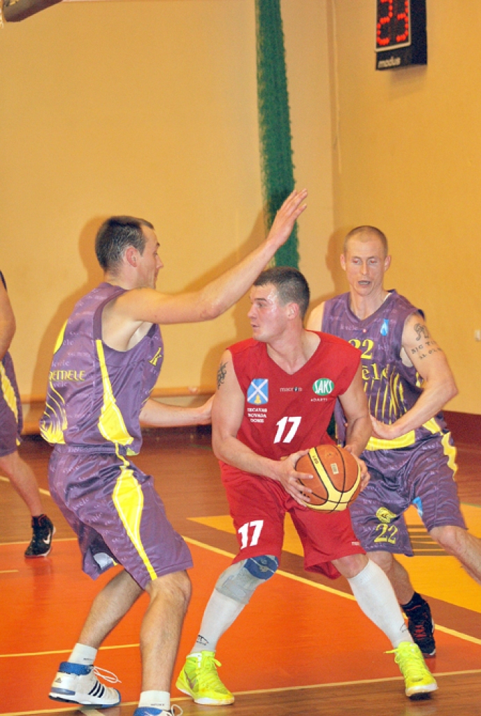 BK «Dartija» spēlētājs Dāvis Kravals (ar bumbu) cīņā ar BK «Kvēle» spēlētājiem Nauri Metnieku (no kreisās) un Armīnu Dīci.