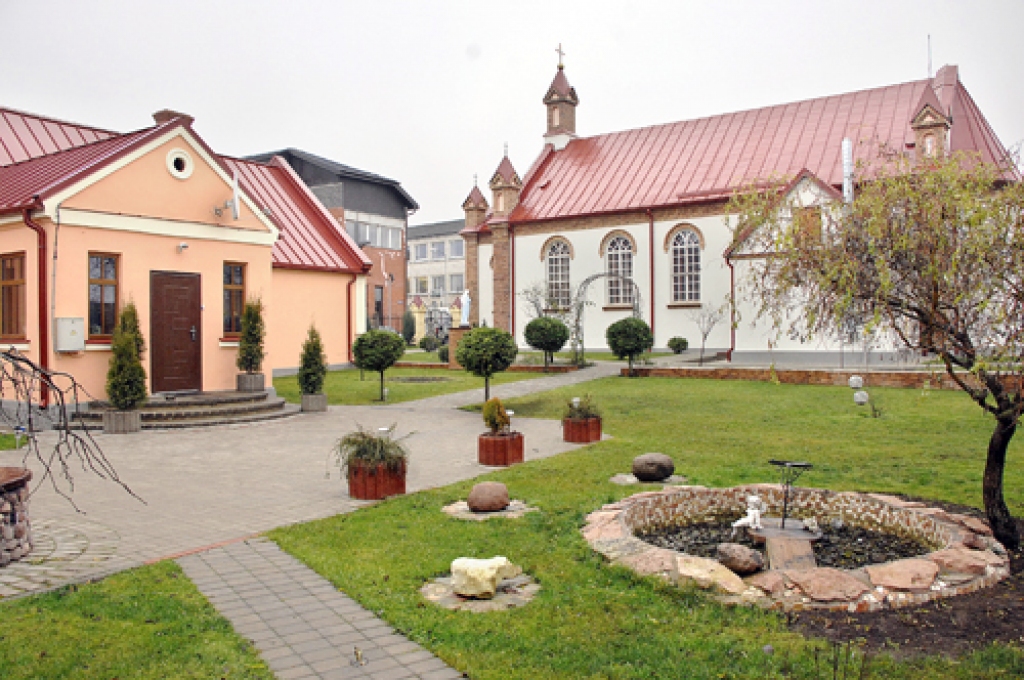 Draudzes māja, kurā dzīvo priesteris, un dārzs.