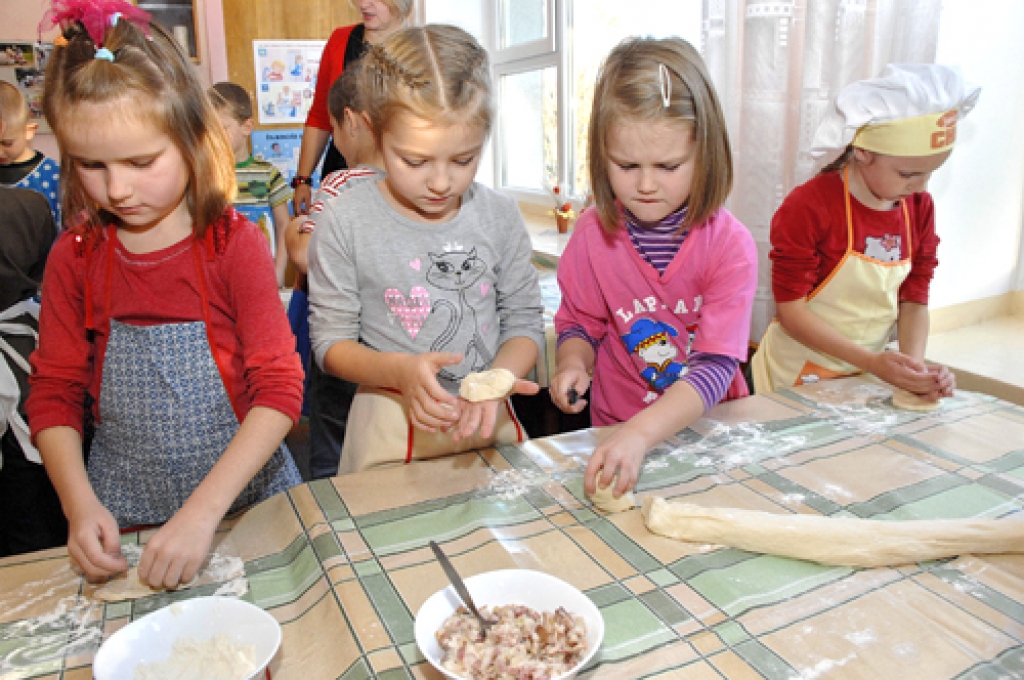 Bērnudārza «Lācītis» vecākās grupas audzēkņi gatavo pīrāgus Mārtiņdienas svinību galdam.