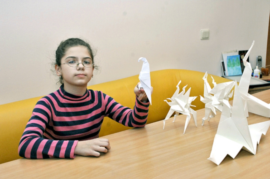 Ērika Sudarkina demonstrē pašas gatavotos papīra pūķus un papagaili. 