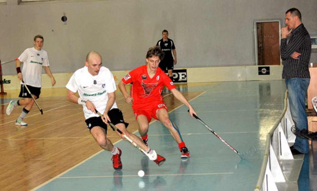 Pēteris Maziks (8. numurs) cīnās par bumbiņu laukumā. Spēli vēro treneris Ingus Panteļejevs (no labās). 