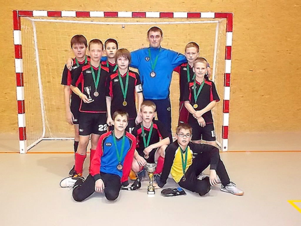 Bauskas bērnu un jaunatnes sporta skolas futbolisti un viņu treneris Artūrs Kupčiuns.