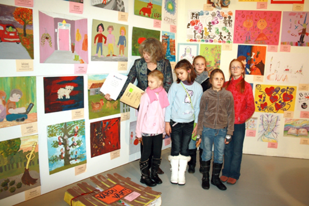 Ilze Arāja, jaunrades pulciņa «Dartija» vadītāja, ar mazajām māksliniecēm konkursā «Valodas eksplozija».
Autors: no skolas arhīva