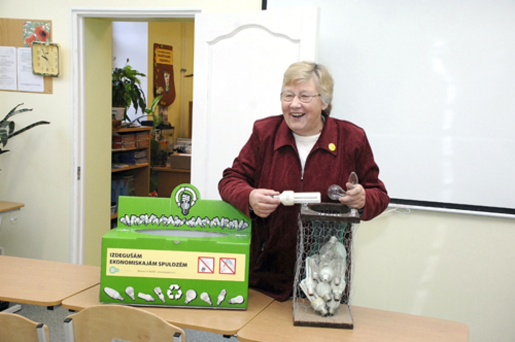 Skolotāja Austra Auguste rāda speciālu kasti, kas ir paredzēta videi bīstamo atkritumu – izdegušo spuldzīšu – savākšanai.