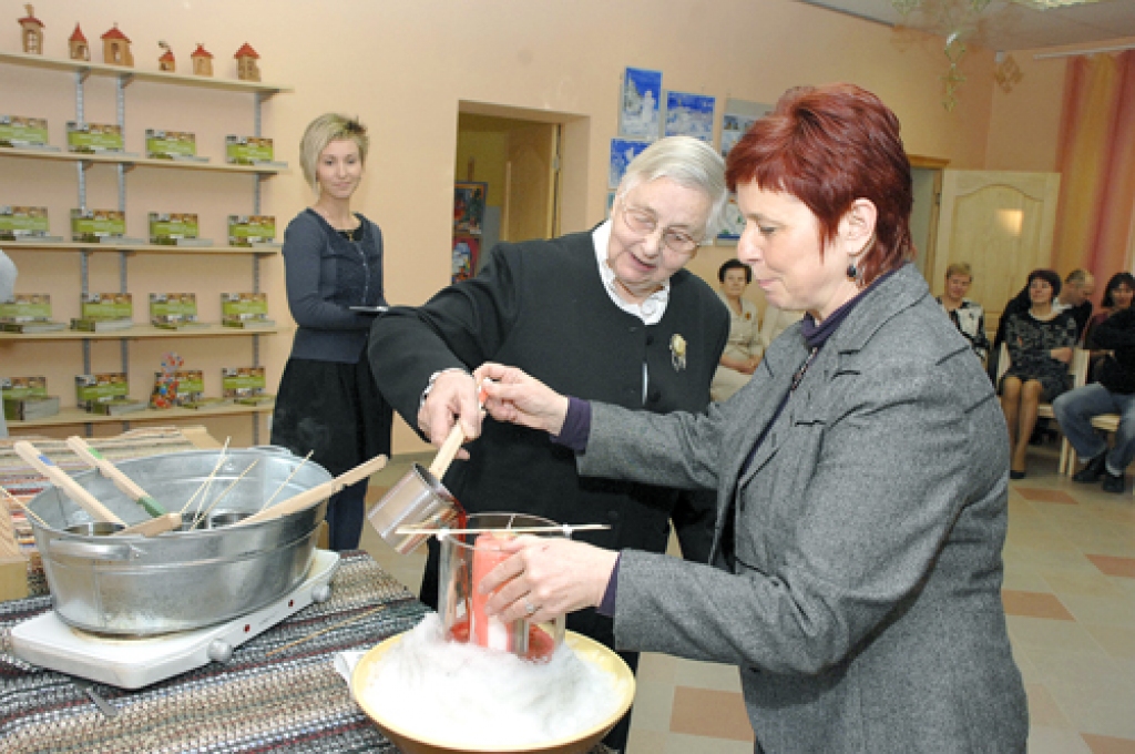 45 gadu jubilejas svecē sarkano krāsu ielej Bauskas bērnu un jauniešu centra ilggadējā vadītāja Laimdota Sala (otrā no labās). Viņai asistē metodiķe Veronika Puķe. 