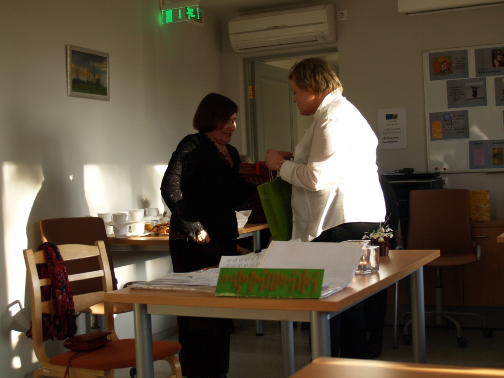 Aina Ezergaile, Zorģu bibliotekāre (no labās), pasniedz viešņai Maijai Laukmanei pateicības dāvanu.
Autors: Antra Ērgle