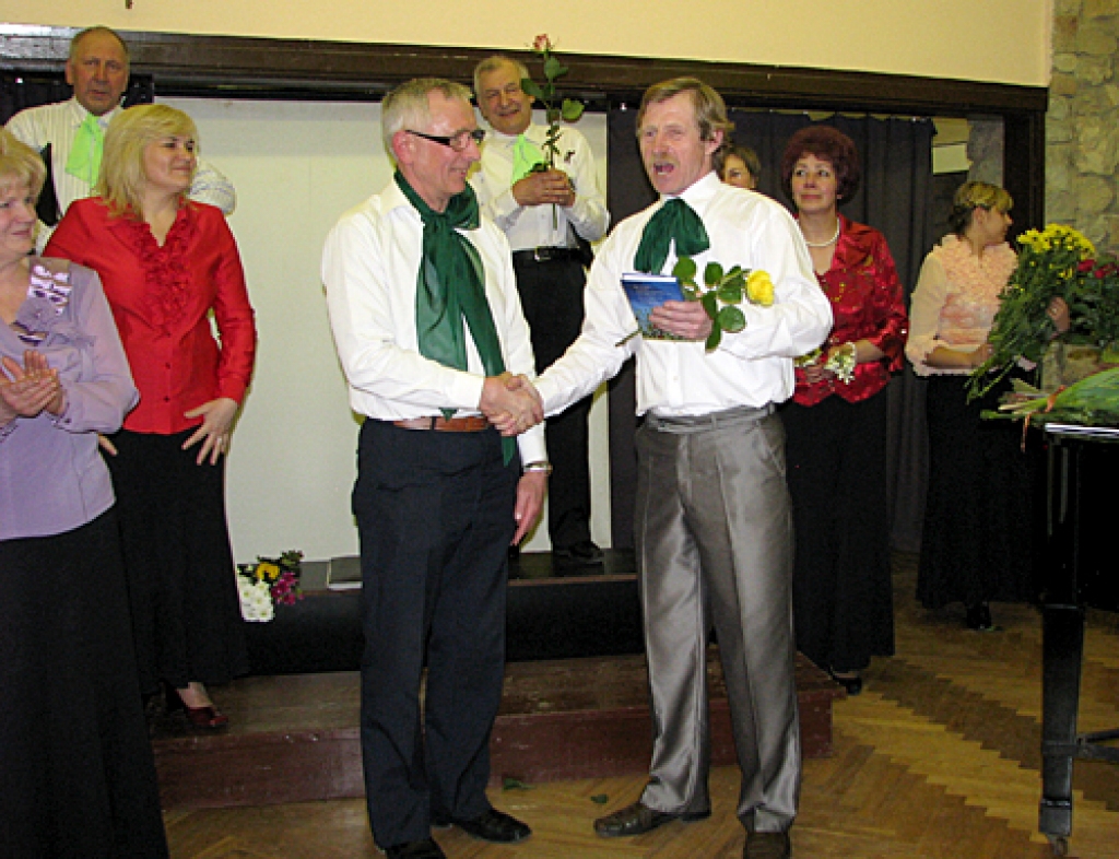 Jubilejas koncertā izskanēja kora dalībnieka Jāņa Mikulāna (no kreisās) komponētās dziesmas «Laimes miljonārs» pirmatskaņojums. Autoru sveic kora prezidents Albīns Baļčūns. 
Autors: Vilnis Auzāns