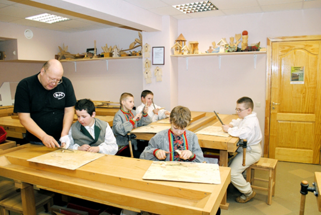 Pēteris Ozols, Bauskas bērnu un jauniešu centra speciālists, māca puišiem koka figūru apstrādi.