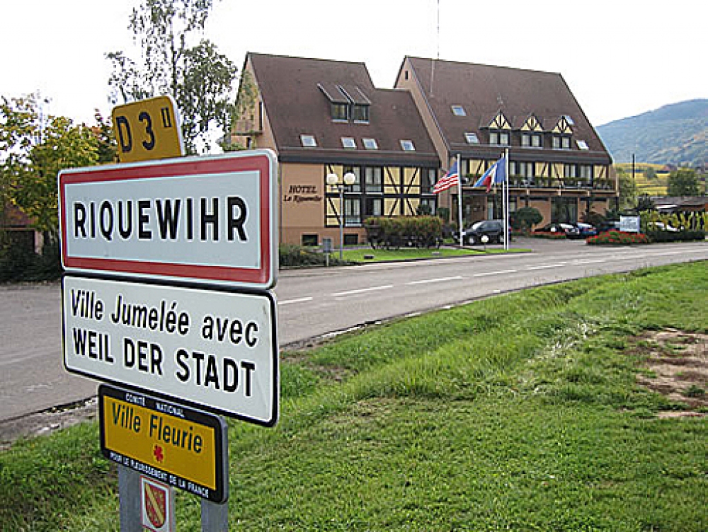 Francijas pilsētiņas Rikvīras norādes zīmi papildina tāfelīte ar vienu ziediņu. 