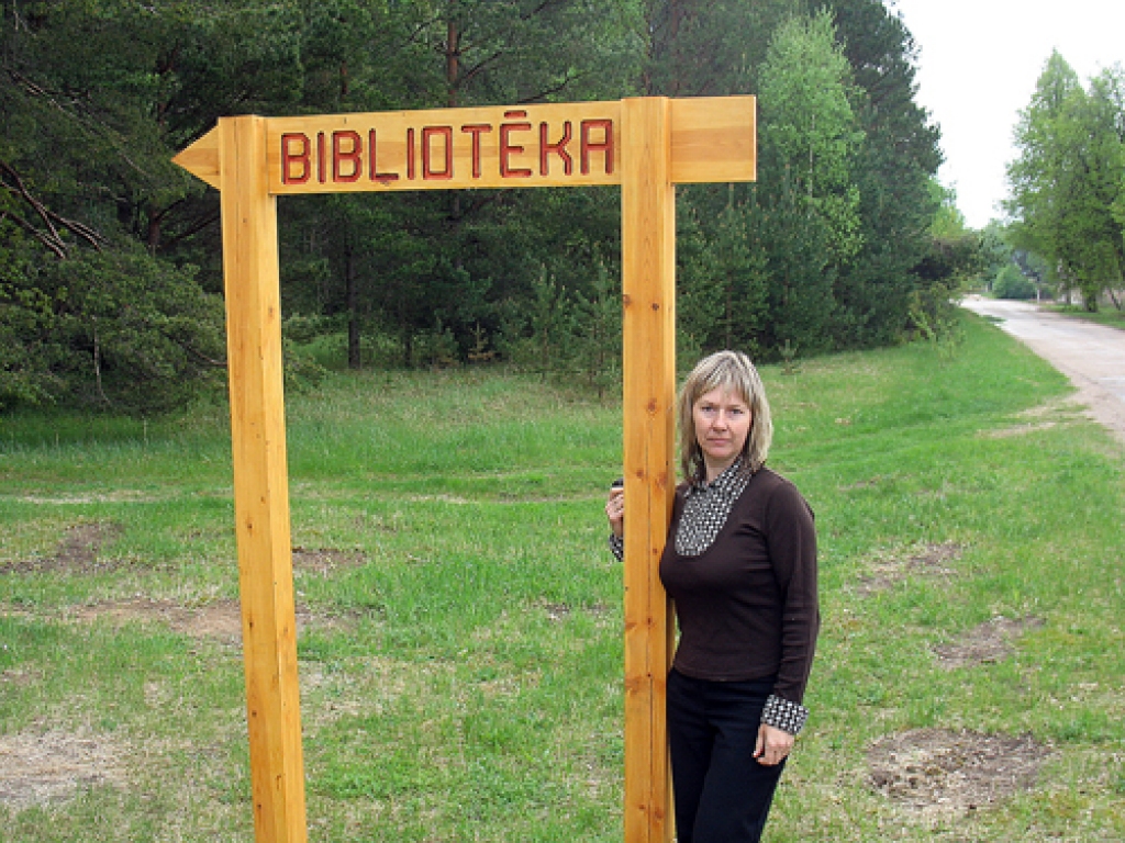 Brigita Čebatarova pie jaunās norādes, kas tika izgatavota pēc Valles pagasta pārvaldes pasūtījuma.