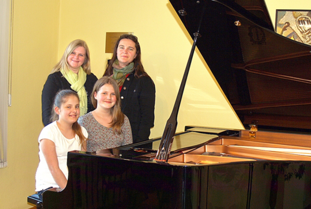 Konkursa dalībnieces Annija Elizabete Goldmane (sēž no kreisās) un  Eva Ķeruže ar pedagoģēm Ivetu Pelši (stāv no labās) un Kristīni Vaičus.