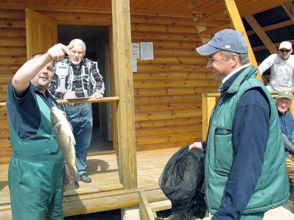 Sergeja Gurčenko (no labās) vislielāko karpu sver sacensību galvenais tiesnesis Raitis Čekšs (no kreisās). 