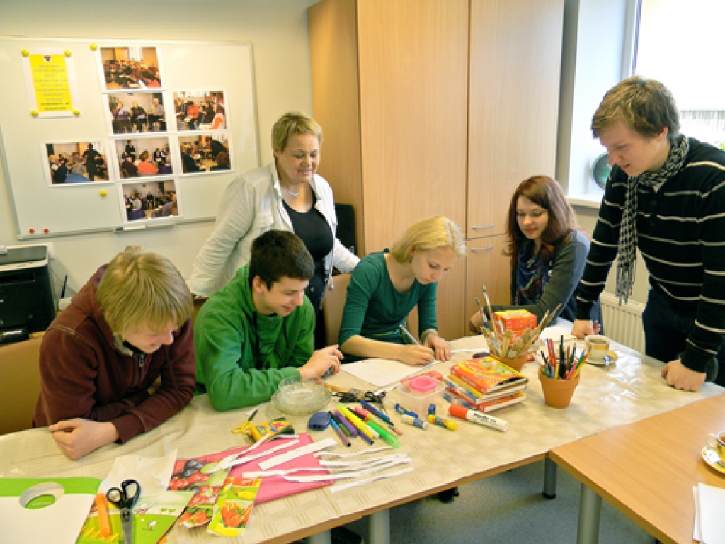 Reinis Pastars (stāv no labās), darbnīcas vadītājs, un Zorģu bibliotekāre Aina Ezergaile vēro jauniešu grupas darbu animācijas filmas tapšanā. 