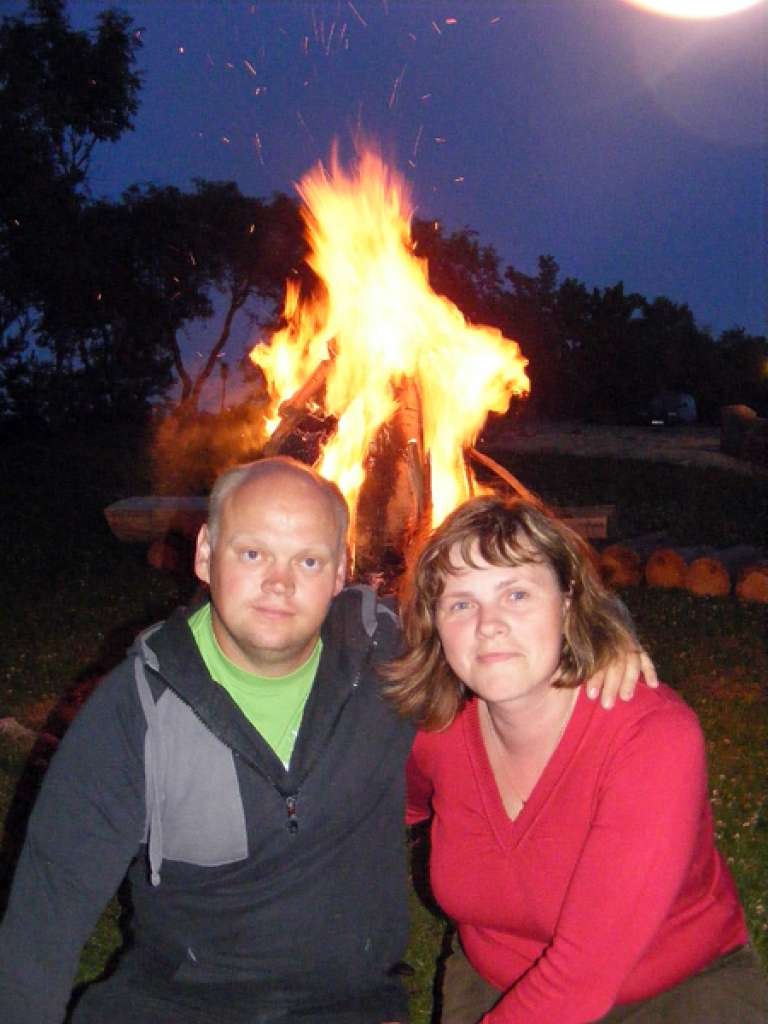 Jānis un Līga malku kārto augstā krāvumā, lai ugunskurs deg visu nakti.