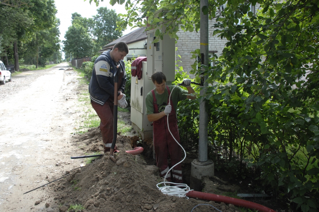 Elektrības kabeli pie jau uzstādītā laternas staba Biržu ielā pievieno SIA «Kvēle» elektromontieri Ģederts Bērziņš (no kreisās)  un Artis Vārna. 
Autors: Ivars Bogdanovs