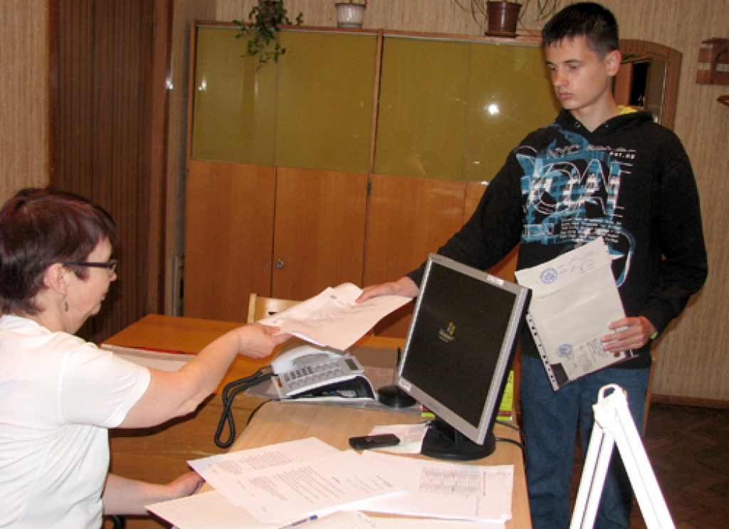 Bauskas Valsts ģimnāzijas lietvede Ruta Klemme pieņem dokumentus no nākamā ģimnāzista Ivo Lukaša. 
Autors: Vilnis Auzāns