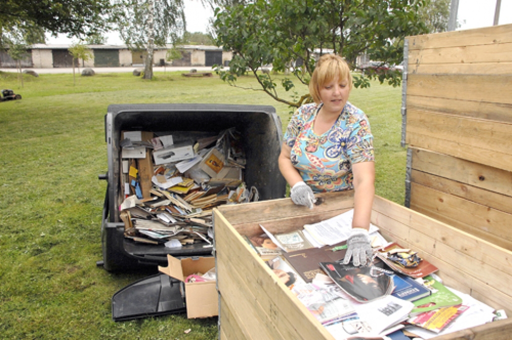 Aelita ramane kārto kastēs makulatūru. 
