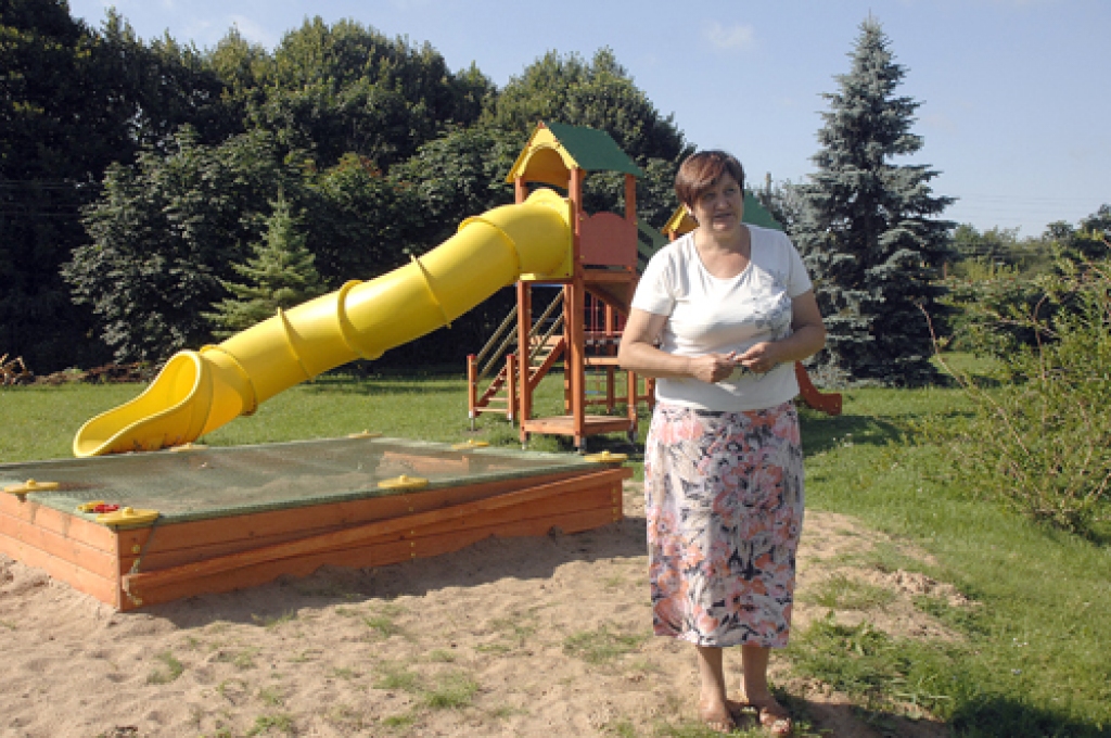 Sarmīte Perševica pie plastmasas slīdkalniņa, kas rada bērniem lielāko prieku.