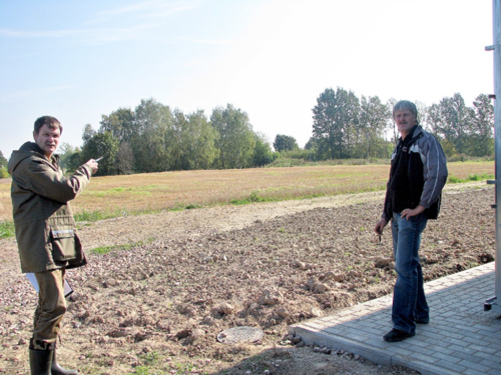 Jelgavas reģionālās vides pārvaldes kontroles daļas vadītājs Andris Ternovskis ( no kreisās) norāda  SIA «Uzvara-Strauti» elektriķim-inženieriem Aivaram Līvmanim uz laukumu, kur 1. oktobrī jābūt uzbūvētai šķidrmēslu krātuvei.
Autors: Vilnis Auzāns