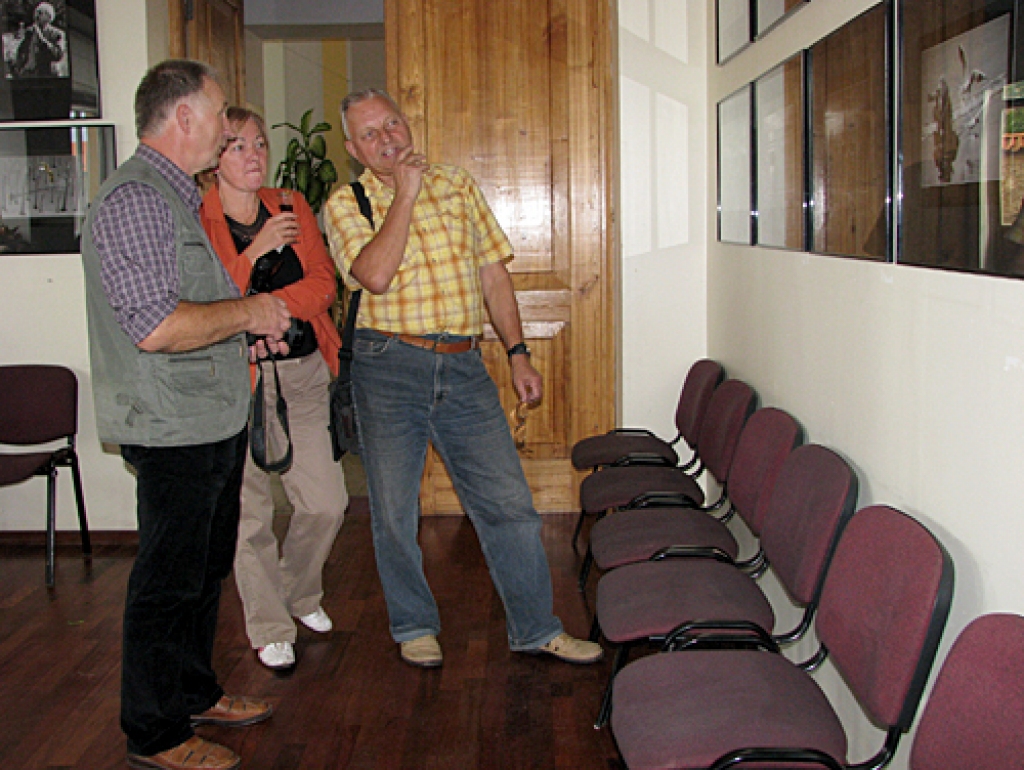 Māris Kreitenbergs (no kreisās) par savām fotogrāfijām stāsta Dainai un Jānim Mičuļiem. 
Autors: Vilnis Auzāns