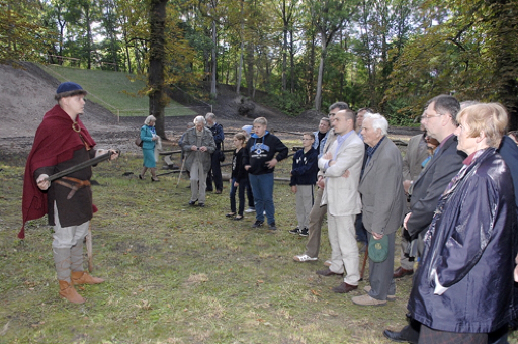 Artūrs Tomsons, domubiedru grupas «Kāvi» vadītājs, pie aizbērtā Mežotnes pilskalna aizsardzības vaļņa stāsta par seno zemgaļu kaujas ieročiem. 