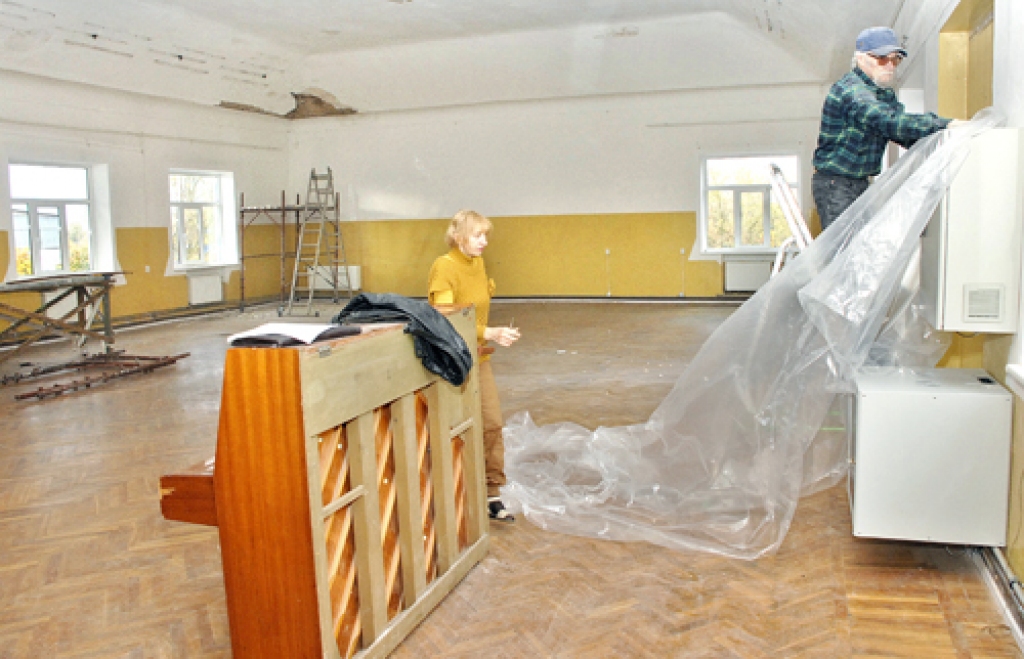 Rītausmu bibliotēkas remonts nupat ir sācies. Aina Pika (no kreisās) ar polietilēna plēvi steidz apsegt pianīno.