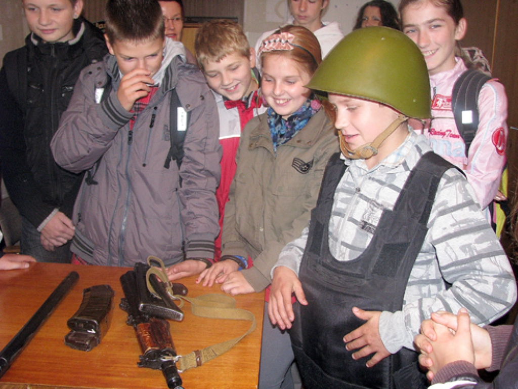 Griķu pamatskolas audzēkņi iepazīst policijas speciālo aprīkojumu. Ķiveri un aizsargvesti laiko 6. klases audzēknis Māris Griba (no labās). 