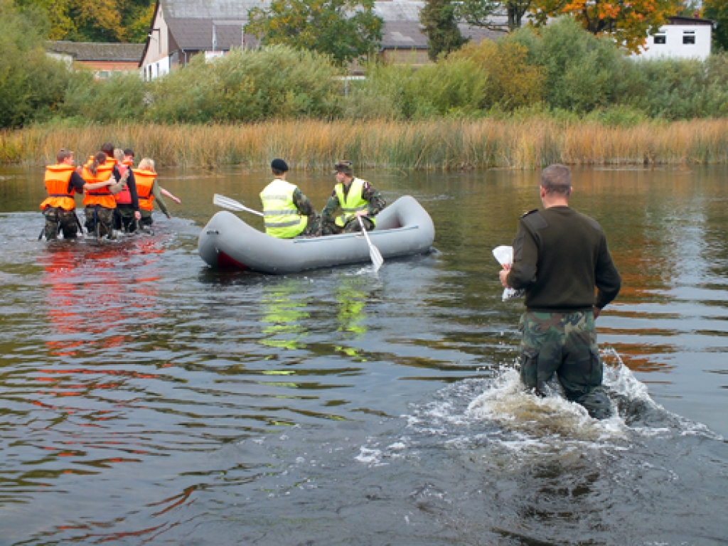 Ūdenī. Jaunsargi imitē munīcijas nešanu pāri upei.