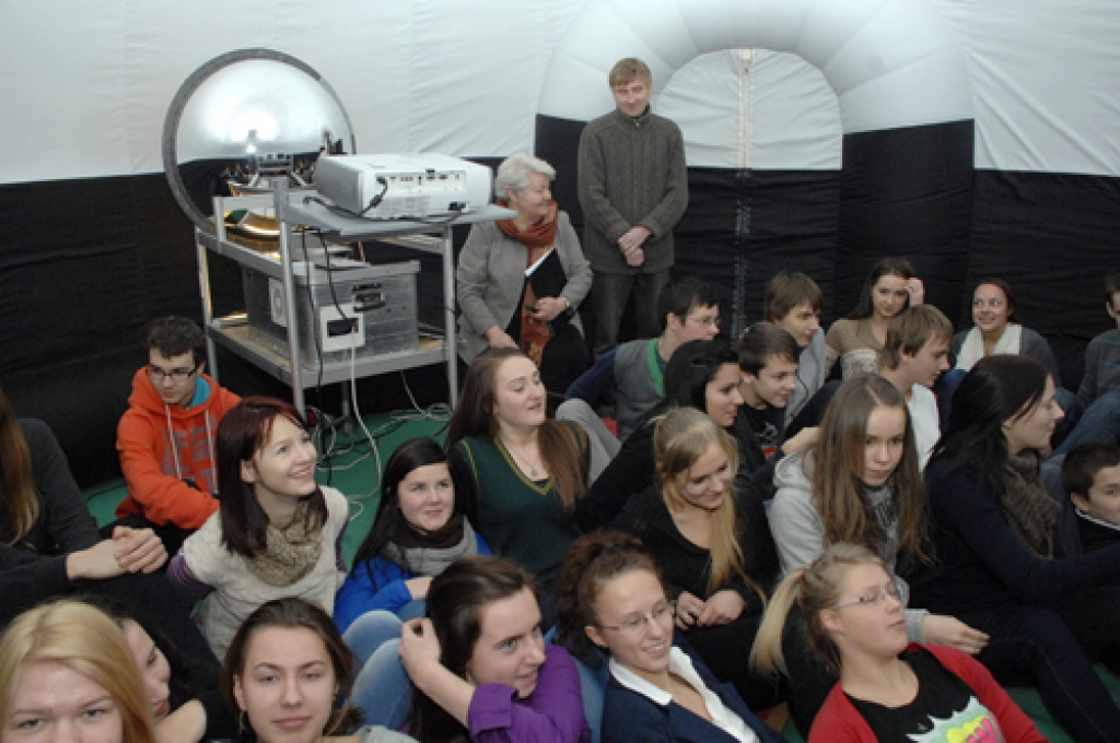 Bauskas Valsts ģimnāzijas audzēkņi, iekārtojušies lodes iekšpusē, gatavojas audiovizuālajai populārzinātniskai lekcijai par Piena ceļu. To ievada skolotājas Maldas Ignatjevas komentārs. 
Autors: Ivars Bogdanovs