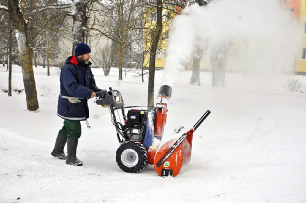 Edgars Gavrilovs ar sniega pūtēju notīra celiņus Rundāles novada Saulaines centrā.