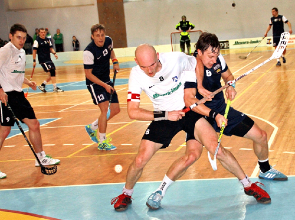 Pēteris Maziks (baltajā kreklā priekšplānā) pret Kristu Štelmaheru – cīņā par bumbiņu liek lietā ne tikai nūju, bet arī muskuļus. 