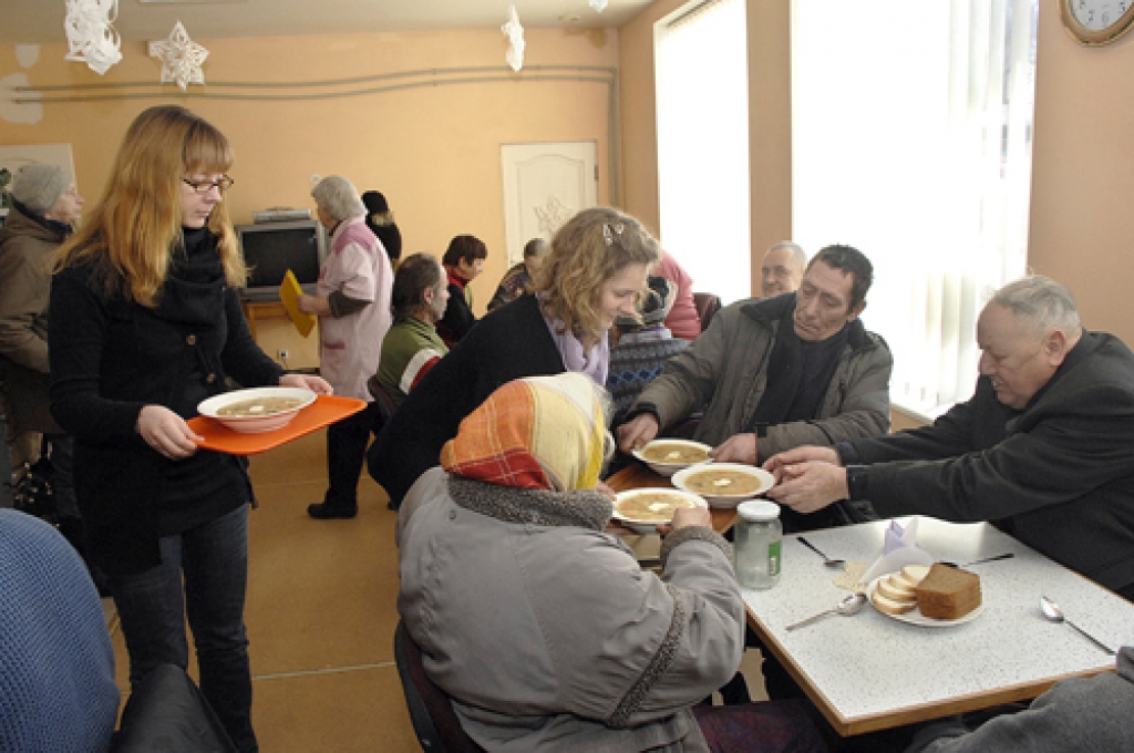 Liene Lazdiņa (pa kreisi) un Karīna Kozlovska, Pestīšanas Armijas Iecavas korpusa vadītājas, apkalpo zupas virtuves apmeklētājus.