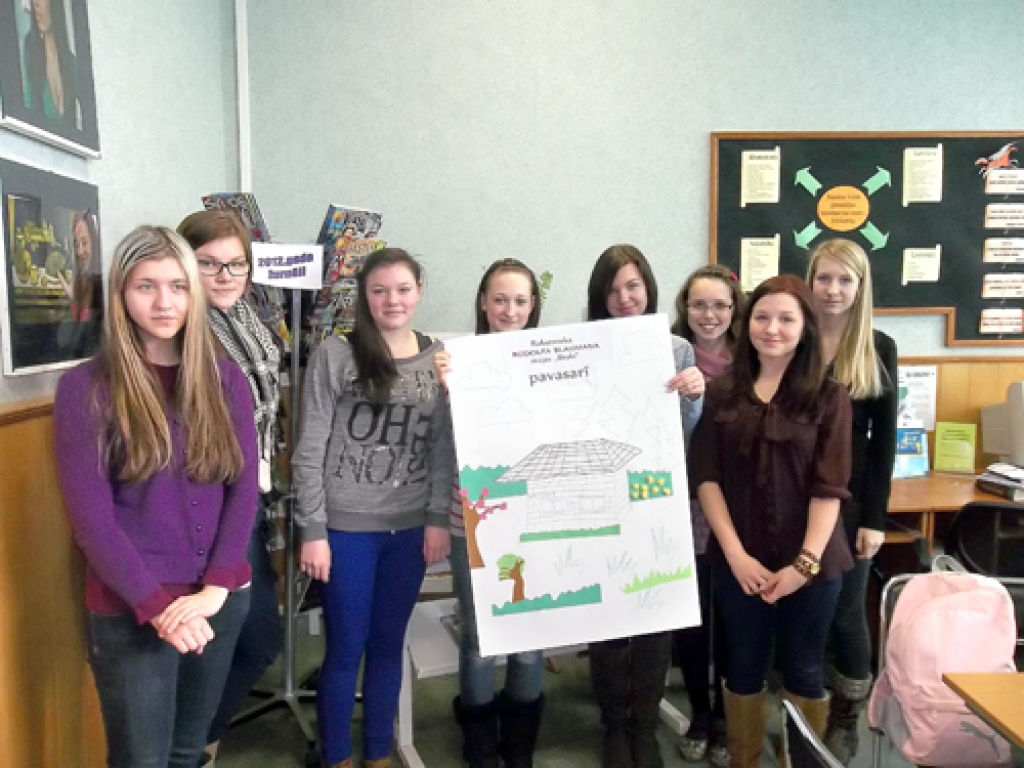 Skolnieces ar kolāžu «Rakstnieka R. Blaumaņa māja «Braki» pavasarī».